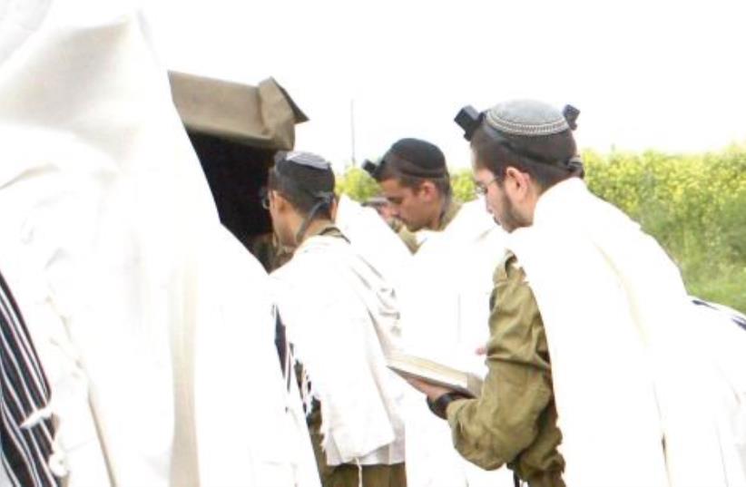 Orthodox infantry soldiers of the Netzah Yehuda Battalion pray in the field (photo credit: Courtesy)