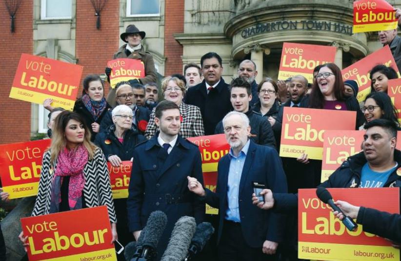 Labor party leader Jeremy Corbyn (center) speaks to the media in northern England (photo credit: REUTERS)