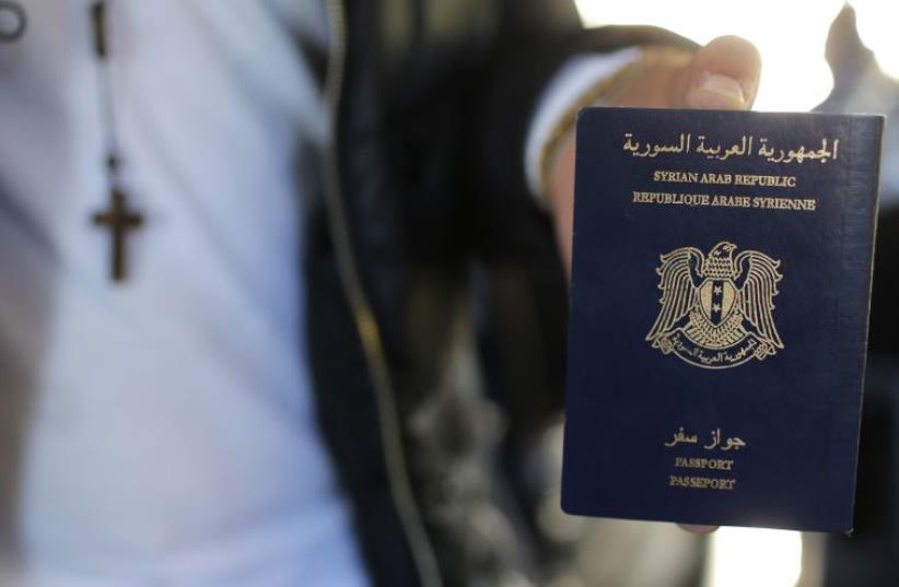 Christian Syrian refugee Ghassan Aleid displays his Syrian passport in France (photo credit: STEPHANE MAHE)