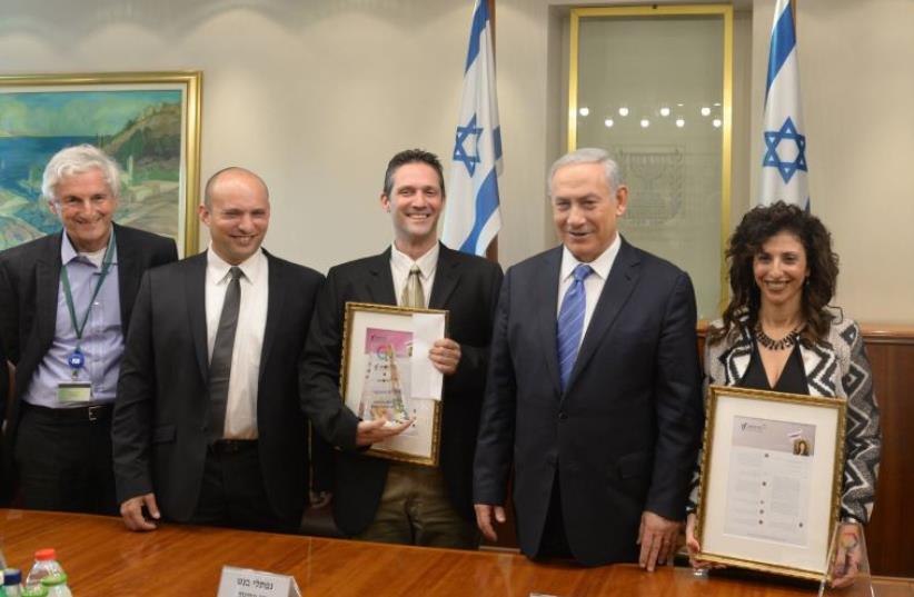 Prime Minister Benjamin Netanyahu presents the Trump prize for educational excellence to Dr. Guy Ashkenazi (photo credit: GPO/AMOS BEN GERSHOM)