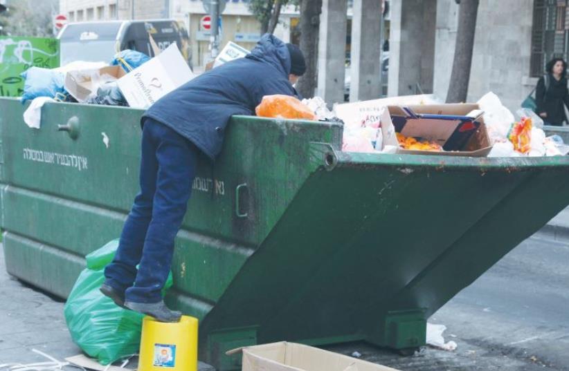 A man in Jerusalem searching through the garbage (photo credit: MARC ISRAEL SELLEM/THE JERUSALEM POST)