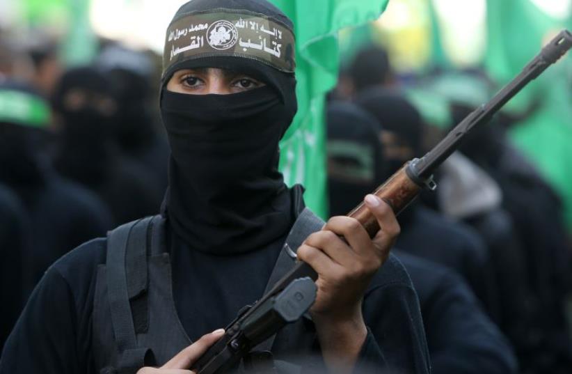 Palestinian militants of the Ezzedine al-Qassam Brigades, the Hamas' armed wing, take part in a rally in Gaza City (photo credit: MAHMUD HAMS / AFP)