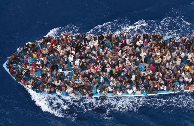 Massimo Sestini’s entry, which took second place in the General News slot, is a colorful overhead shot of refugees packed into a boat off the Libyan coast, prior to being rescued by an Italian naval frigate. (photo credit: MASSIMO SESTINI)