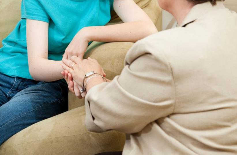 Depressed girl gets counseling and comfort from a caring therapist (photo credit: INGIMAGE)