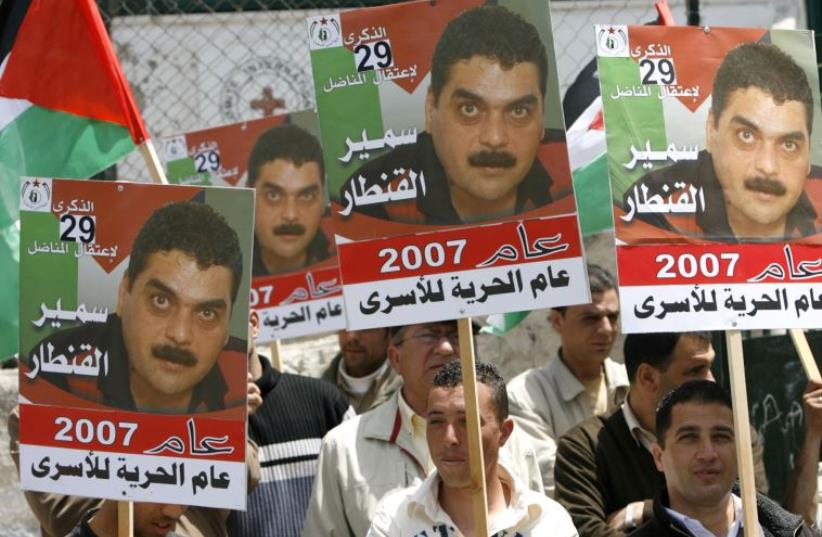A Palestinian supporter of the Islamic Jihad holds a picture of Samir Kuntar,  (photo credit: MOHAMAD TOROKMAN/REUTERS)