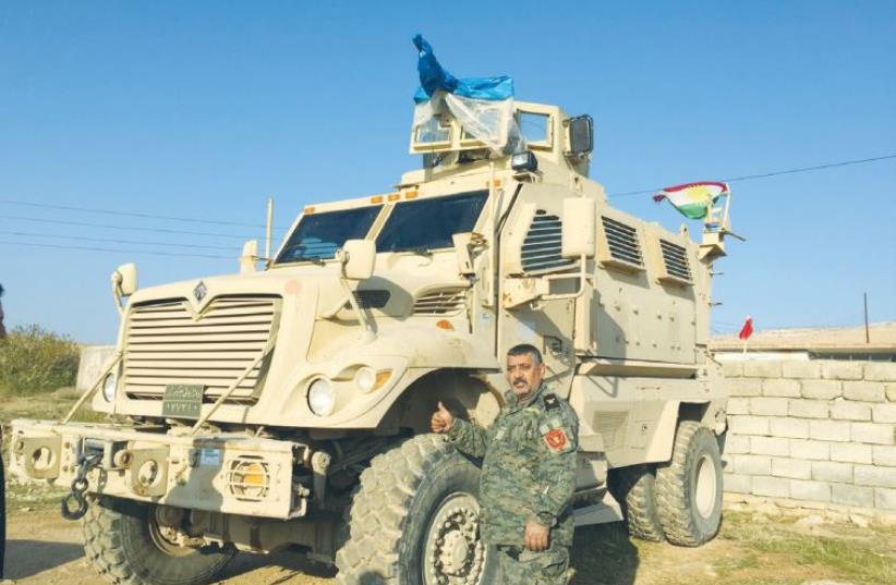 MAJ. ADEL SLEMAN stands next to his specially designed truck, used in de-mining Shingal after Kurdish forces drove Islamic State out (photo credit: SETH J. FRANTZMAN)