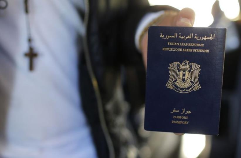 Christian Syrian refugee Ghassan Aleid displays his Syrian passport at a terminal at the Charles-de-Gaulle Airport in Roissy, France (photo credit: REUTERS)
