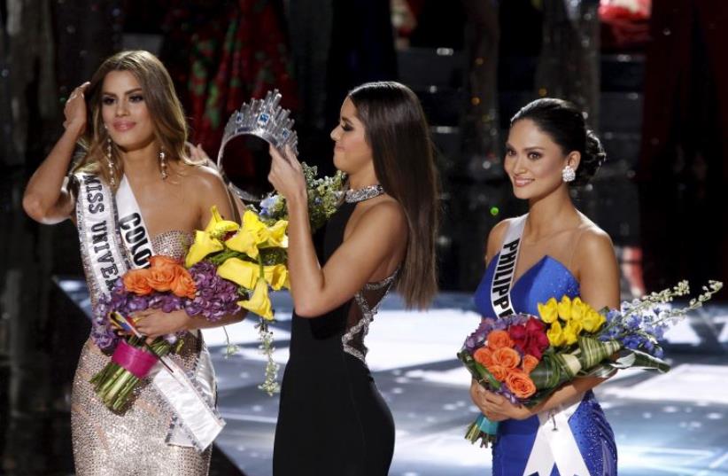 Miss Colombia Ariadna Gutierrez (L) stands by as Miss Universe 2014 Paulina Vegas transfers the crown to winner Miss Philippines Pia Alonzo Wurtzbach (R) during the 2015 Miss Universe Pageant in Las Vegas, Nevada, December 20, 2015 (photo credit: REUTERS)
