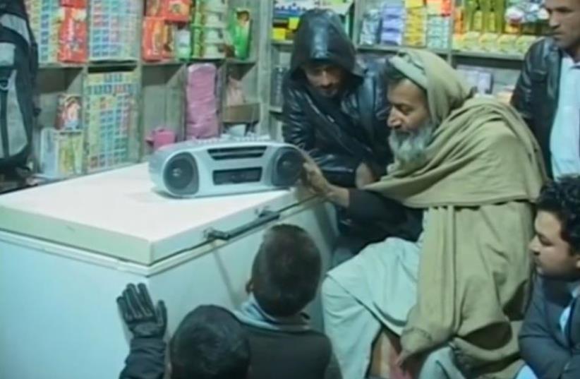 Afghani residents tuning in to ISIS broadcast on radio. (photo credit: REUTERS)