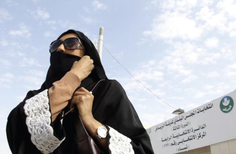 A Saudi woman leaves a polling station after casting her vote during municipal elections in Riyadh on December 12 (photo credit: REUTERS)