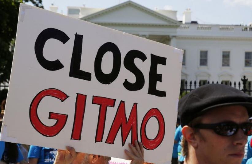 Activist holds a sign at a rally next to the White House in Washington calling for the closure of the US-run Guantanamo Bay prison in Cuba (photo credit: REUTERS)