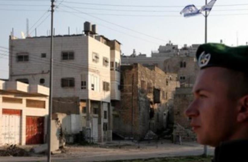 IDF soldier stands guard next to Beit Hamachpela in Hebron. (photo credit: MARC ISRAEL SELLEM)