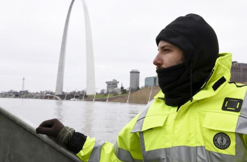 US Geological Survey (USGS) hydro technician Jason Carron assesses the Mississippi River flood waters in St. Louis (photo credit: REUTERS)