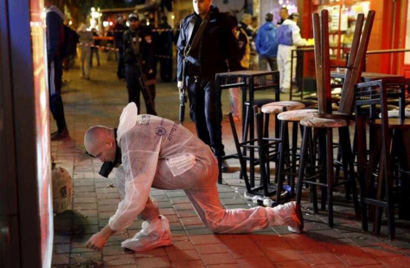 Israeli forensic policemen work at the scene of a shooting incident in Tel Aviv (photo credit: REUTERS)