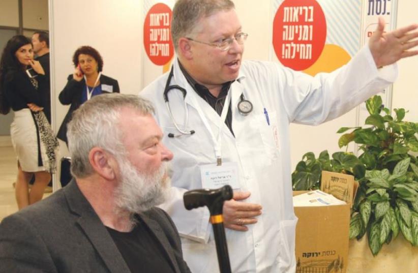 MK ILAN GILON (Meretz) hears an explanation from a physician at the Knesset yesterday during the legislature’s second annual Health Day (photo credit: KNESSET)