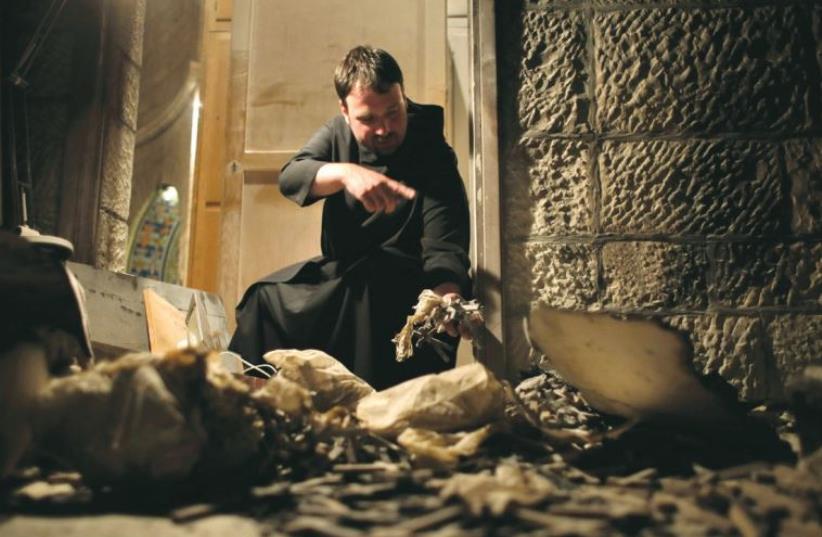 A PRIEST points to damage at the Dormition Abbey on Mount Zion after an arson attack on May 26, 2015 (photo credit: REUTERS)