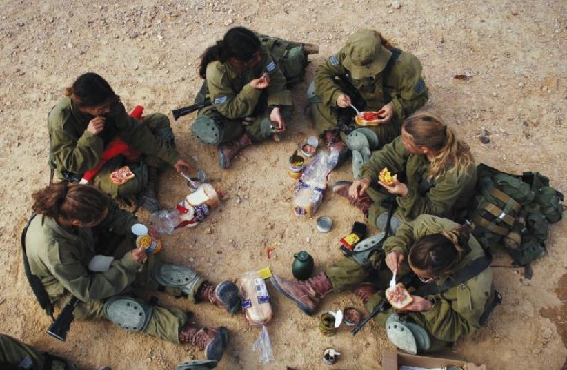 SOLDIERS SIT for a shared meal during training. IDF regulations are supposed to favor lone soldiers in giving them extra time to complete errands outside the army, but some say that this is not being honored. (photo credit: LONE SOLDIER CENTER IN MEMORY OF MICHAEL LEVIN)