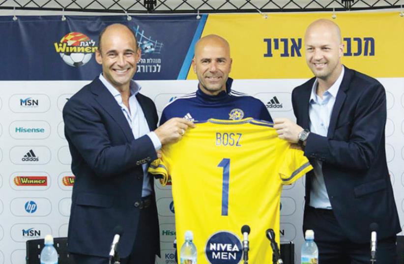Peter Bosz (center) was unveiled as the new coach of Maccabi Tel Aviv by CEO Peter Bain (left) and sports director Jordi Cruyff (right) yesterday at the club’s Kiryat Shalom training complex in Tel Aviv. (photo credit: MACCABI TEL AVIV WEBSITE)