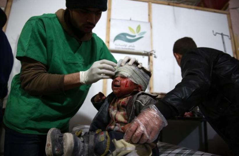 A Syrian child receives treatment at a make-shift hospital, following a reported airstrike by Syrian government forces on the rebel-held town of Douma (photo credit: AFP PHOTO)