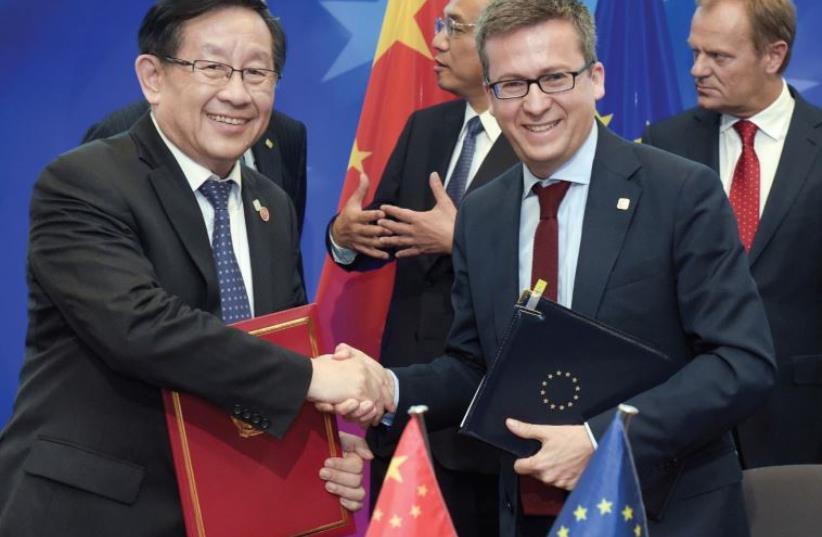 European commissioner for Research Carlos Moedas shakes hands with Xu Shaoshi, chairman of the National Development and Reform Commission during a EU-China summit last year in Brussels, Belgium (photo credit: REUTERS)