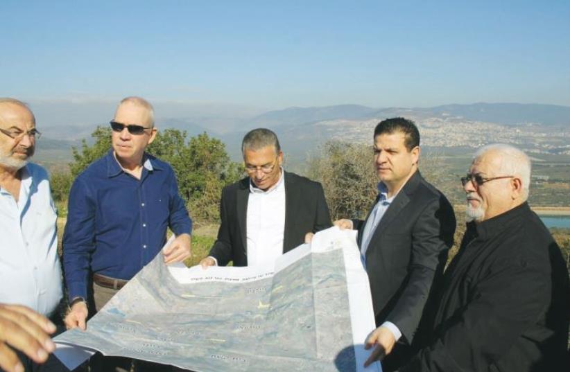 CONSTRU CTION MINISTER Yoav Galant (second from left) and Joint List leader Ayman Odeh (second from right) discuss Arab-housing development plans with leaders of the community in the North yesterday. (photo credit: JOINT LIST)