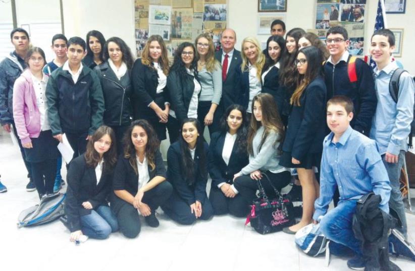 Students participating in the after-school Model UN program pose with Thomas Genton (center), the counselor for press and cultural affairs at the US Embassy in Tel Aviv (photo credit: LAURA KELLY)