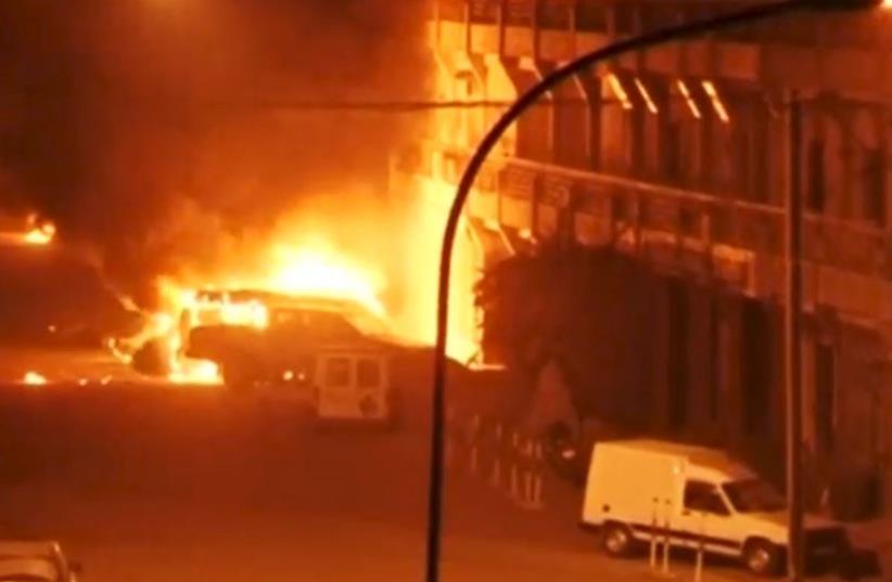 A view shows vehicles on fire outside Splendid Hotel in Ouagadougou, Burkina Faso in this still image taken from a video January 15, 2016 (photo credit: REUTERS)