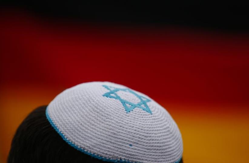 A man wearing a kippa listens to speakers during an anti-Semitism demo at Berlin's Brandenburg Gate September 14, 2014 (photo credit: REUTERS)