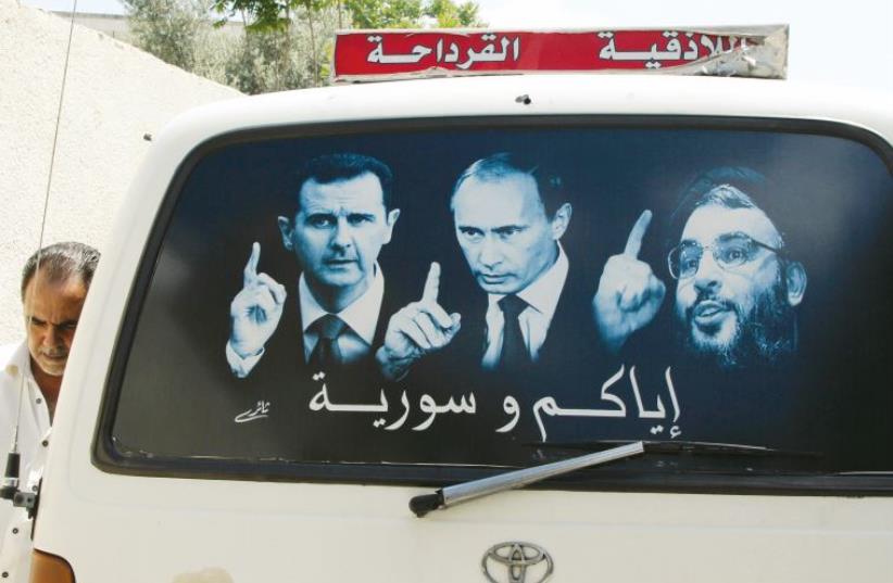 A poster shows Assad, Russian President Vladimir Putin and Lebanese Hezbollah leader Sayyed Hassan Nasrallah near Latakia city in 2014 (photo credit: REUTERS)