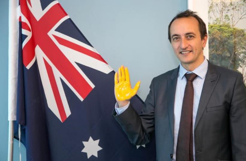 ustralian Ambassador to Israel Dave Sharma with his palm painted yellow to sign the virtual wall. (photo credit: BENI LAPID)
