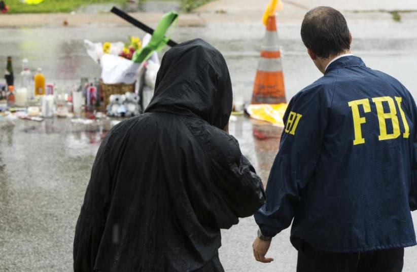 An FBI agent interviews a resident of Ferguson, Missouri. (photo credit: LUCAS JACKSON / REUTERS)
