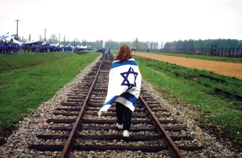 A PARTICIPANT in a previous March of the Living walks along the railway spur leading into Birkenau (photo credit: Courtesy)