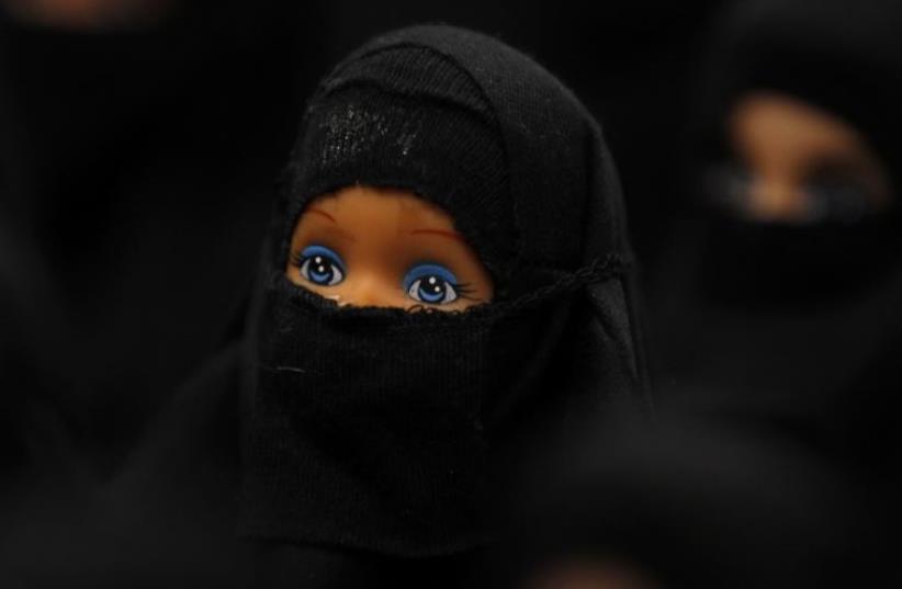 The installation 'Sheltered position' of German artist Sabine Reyer shows one hundred Barbie dolls dressed with burkas at the Ruhr-Biennale in Dortmund (photo credit: REUTERS)