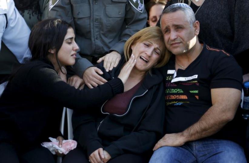 The parents of Border Policewoman, Hadar Cohen, 19, mourn during their daughter's funeral at the military cemetery in Yehud (photo credit: REUTERS)