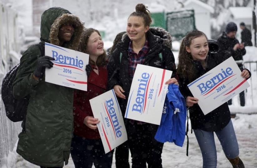 Girls supporting US Democratic presidential candidate Bernie Sanders cheer for Bernie during snowfall outside a campaign event in Exeter, New Hampshire (photo credit: REUTERS)