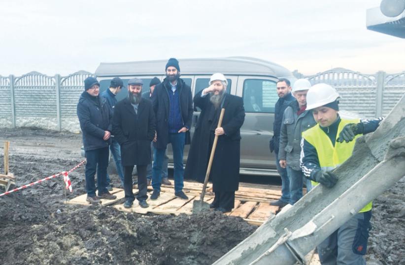 RABBI MOSHE AZMAN symbolically kicks off construction of the foundation for a building to house refugees in Anatevka, just outside Kiev, last week. (photo credit: SAM SOKOL)