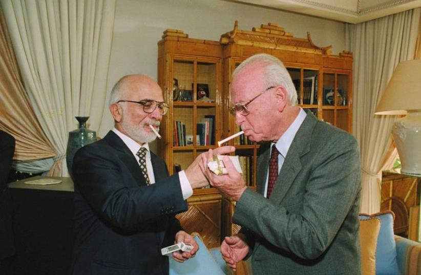 Jordan's late King Hussein (L) offers then-premier Yitzhak Rabin a cigarette at his palace in Aqaba (photo credit: GOVERNMENT PRESS OFFICE)