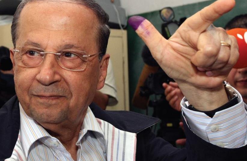 LEBANESE CHRISTIAN opposition leader Michel Aoun of Free Patriotic Movement shows his ink-stained finger after casting his ballot at a polling station in Beirut’s suburbs in 2009. (photo credit: REUTERS)