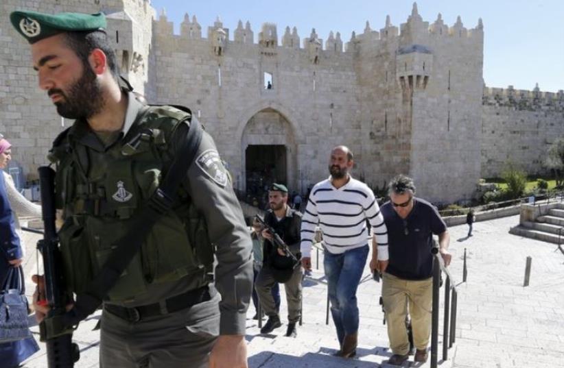  Caption: Washington Post bureau chief William Booth and Sufian Taha are escorted by police outside the Old City’s Damascus Gate on Tuesday afternoon. (photo credit: REUTERS)