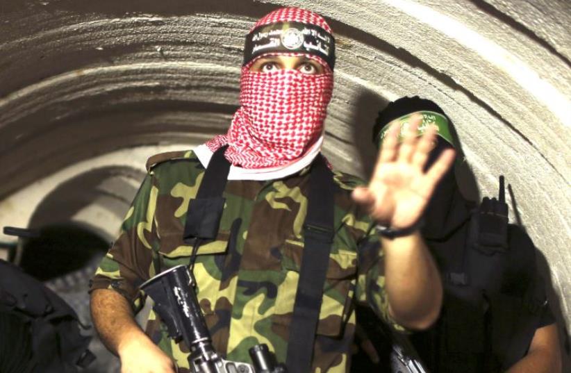 A gunman from the Izz ad-Din al- Qassam Brigades, the armed wing of Hamas, photographed inside an underground tunnel in Gaza, in 2014. (photo credit: REUTERS)