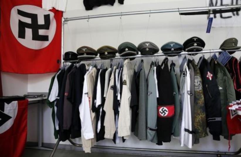 Nazi uniforms and a Swastika flag that were confiscated by the Berlin police during raids against German neo-Nazis (photo credit: REUTERS)