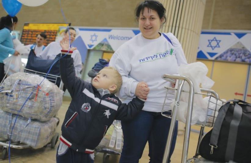A UKRAINIAN boy grabs a balloon that is decorating the arrivals area of Ben-Gurion Airport in Tel Aviv yesterday to welcome the Ukrainian families making aliya. (photo credit: DANIEL BAR-ON)