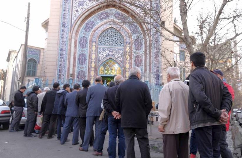 Iranians stand in line to cast their votes during elections for the parliament and Assembly of Experts (photo credit: REUTERS)
