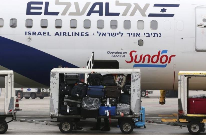 Baggage carts are seen on the tarmac near an El Al Israel Airlines plane at Venice airport (photo credit: REUTERS)
