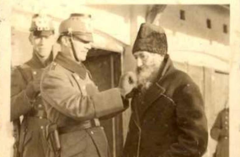 Nazi cutting beard of elderly Jew, Kielce, Poland (photo credit: YAD VASHEM)