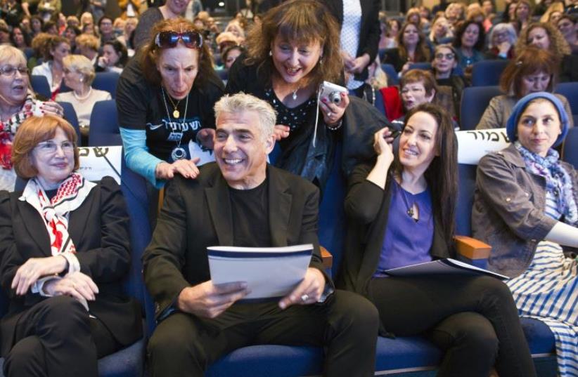 Yesh Atid leader Yair Lapid and his wife Lihi attend a women's committee convention in Tel Aviv (photo credit: NIR ELIAS / REUTERS)