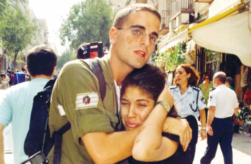 A soldier comforts a survivor of a Ben-Yehuda Street bombing in 1997 (photo credit: BRIAN HENDLER)