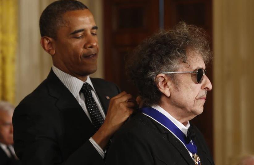 U.S. President Barack Obama awards a 2012 Presidential Medal of Freedom to musician Bob Dylan during a ceremony in the East Room of the White House in Washington, May 29, 2012. (photo credit: REUTERS)