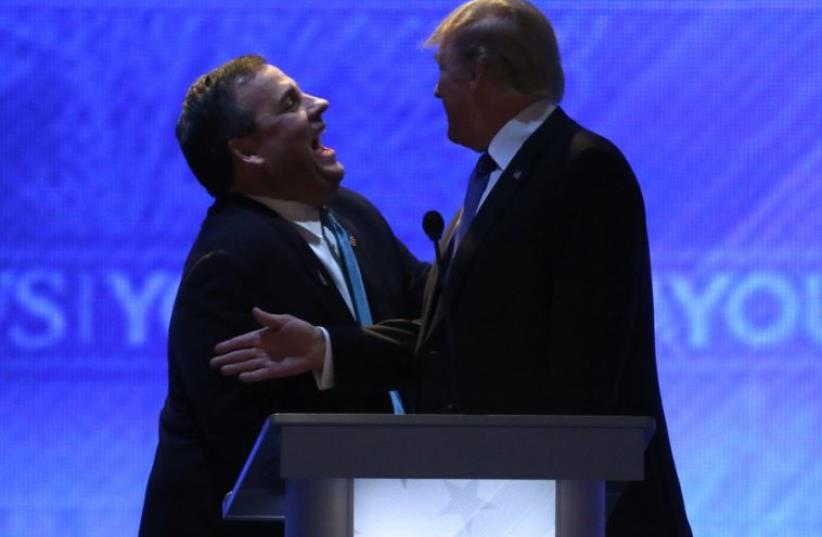Chris Christie and Donald Trump laugh together during a commercial break in the midst of the February 6 Republican debate in New Hampshire (photo credit: REUTERS)