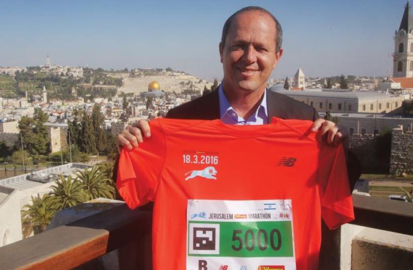 Mayor Nir Barkat – holding a Jerusalem Marathon T-shirt – kicks off the 2016 race with a press conference (photo credit: MARC ISRAEL SELLEM)